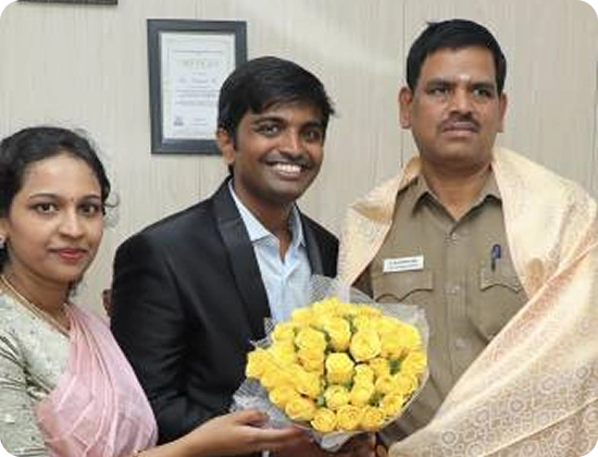 Dr Easwar and Dr Ramya Lakshmi presenting a bouquet to a police officer.