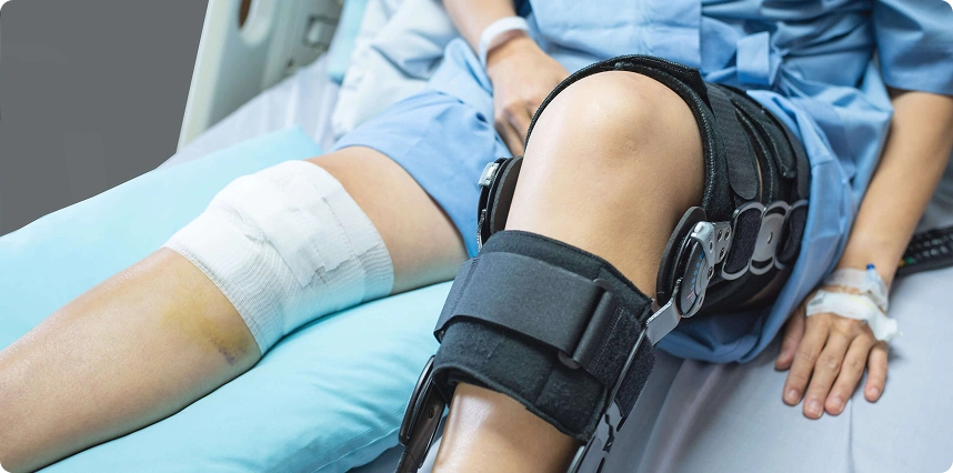 Patient wearing knee brace after surgery or ligament injury during recovery.